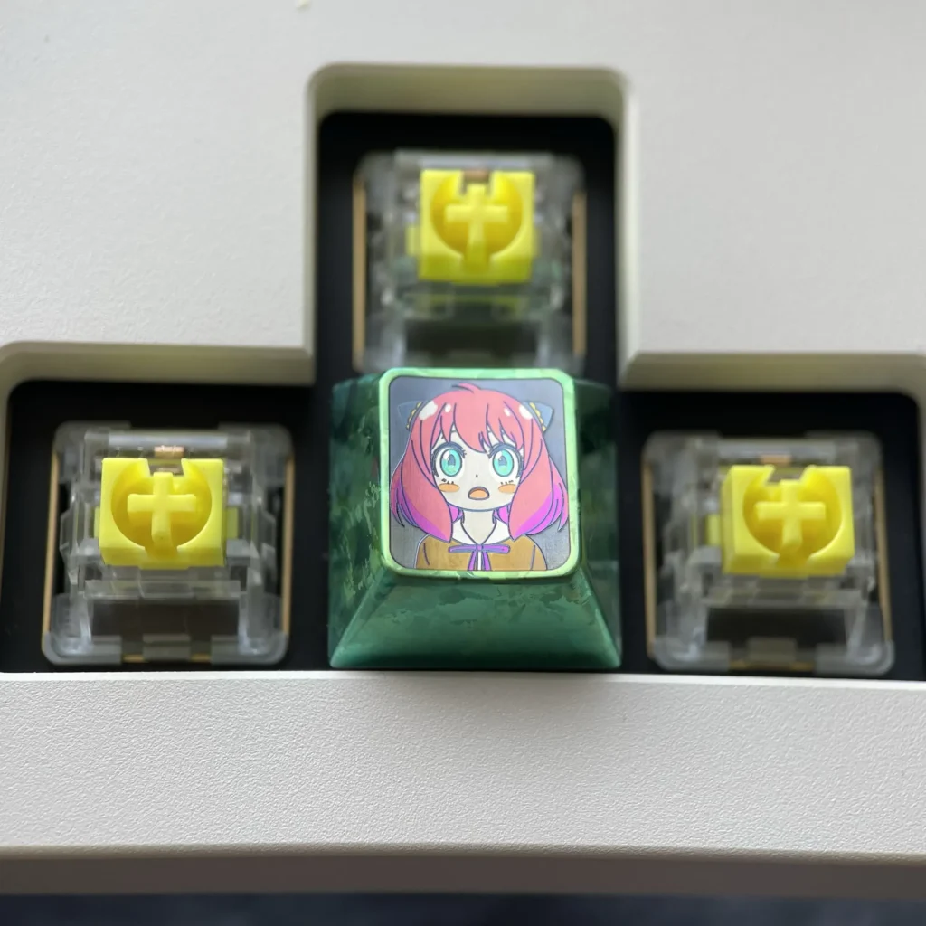Artistic display of the vibrant Anya Forger titanium alloy keycap set, highlighting her iconic anime expressions on each lustrous key.