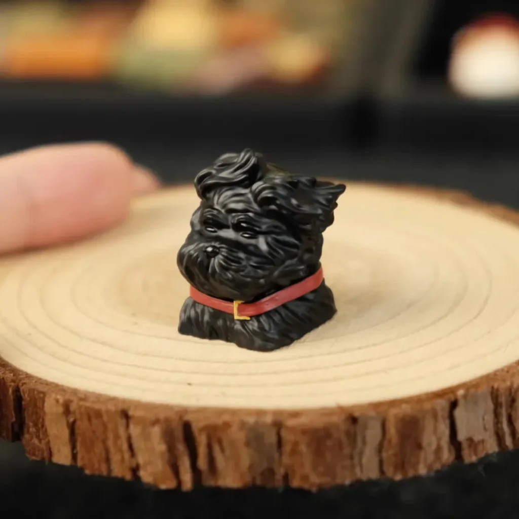 Delightful handcrafted resin black puppy artisan keycap, captured mid-play with a whimsical gust of wind detail.