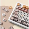 Playful calico cat keycaps set from different angles, showcasing vibrant PBT dye-sub illustrations and MAO profile on a custom mechanical keyboard.