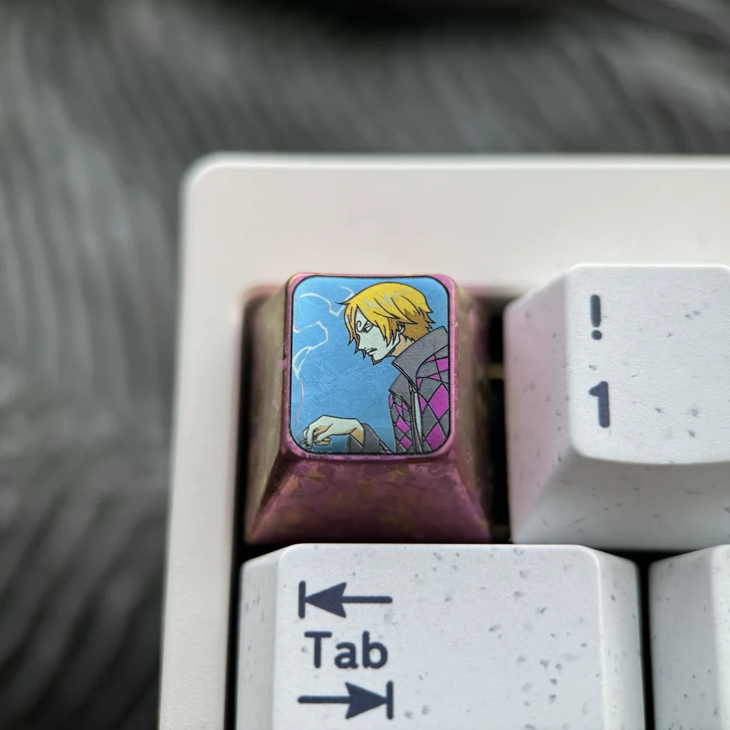 Close-up of the premium titanium ONE PIECE artisan keycap, highlighting its iconic vibrant anime design and intricate metal craftsmanship.