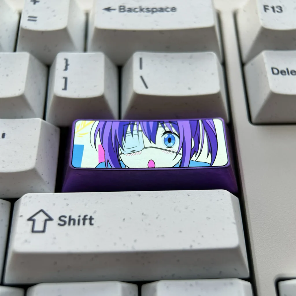 Multiple views of the premium titanium Rikka Takanashi keycap, showcasing its vibrant metallic sheen and intricate anime custom detailing.
