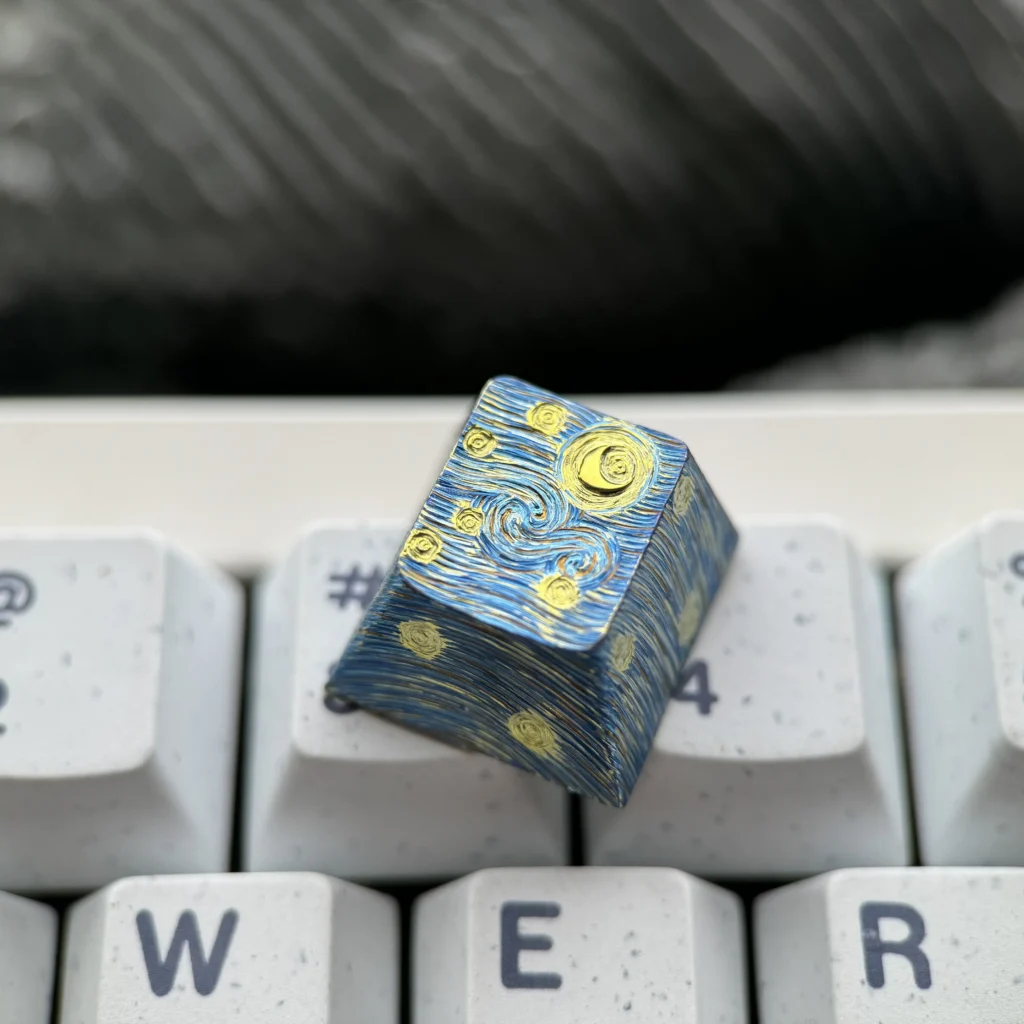 Hand-carved titanium Van Gogh Starry Night keycap from multiple angles, highlighting its intricate relief texture and metallic finish.