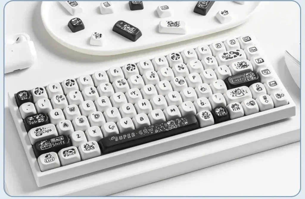 Whimsical Super Cow keycaps set gallery. Durable PBT dye-sub MOA profile full set shown from various angles, highlighting the charming black and white design.