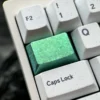 Close-up of a premium Ice Crystal Titanium Keycap, showcasing its shimmering, jewel-like facets and vibrant metallic color.