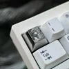 Multiple angles of the precision hand-carved titanium Violet Evergarden keycap. Reveals intricate artisan details and a lustrous finish, a unique design.