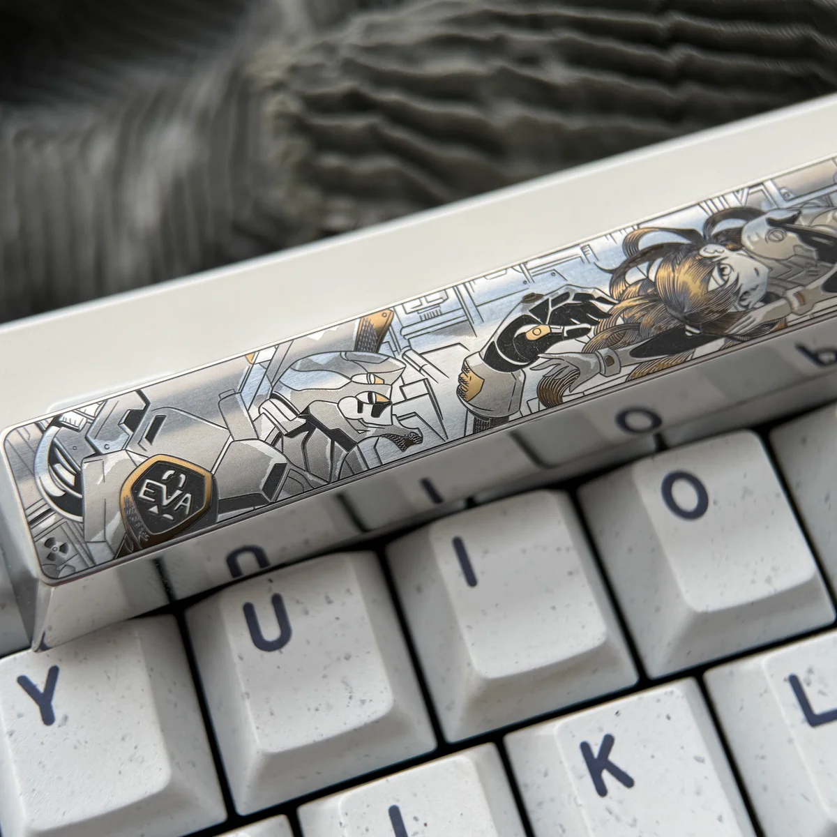 Close-up views of the precision-engraved Asuka Titanium Spacebar keycap, showcasing its vibrant anime mecha design and intricate details from multiple angles.