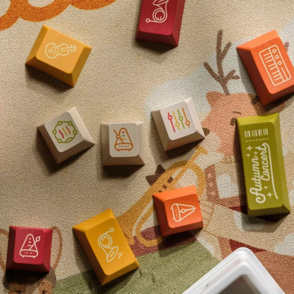Autumn Concert Dye-sub PBT keycaps set, shown from various angles. Displays warm, earthy tones, vintage musical instruments, and serene autumn design.