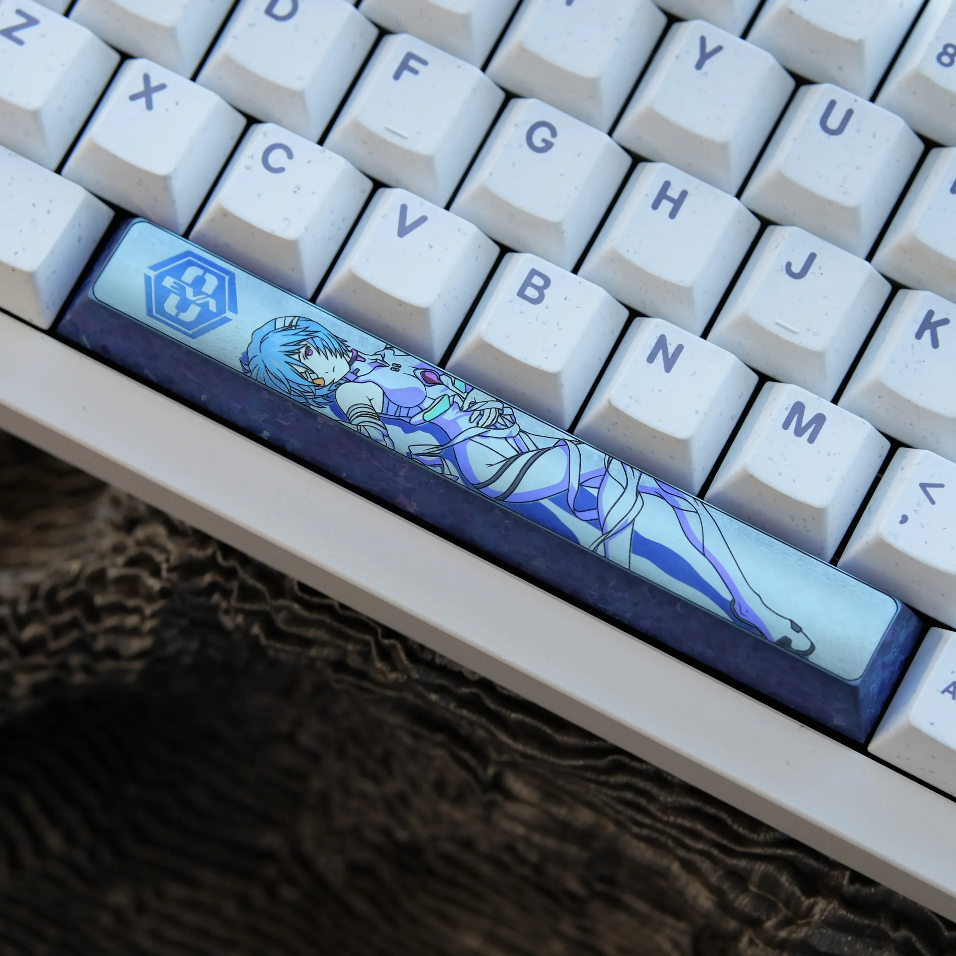 Showcases the iconic Ayanami Rei titanium space key keycap, a premium Evangelion artisan piece with vibrant sci-fi anime art.