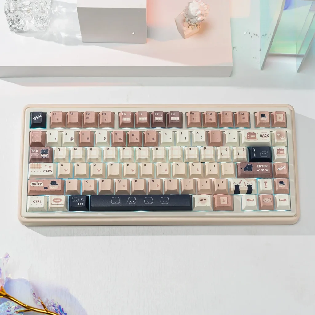 Whimsical Cat Keycap Set: Durable PBT dye-sub keycaps with charming feline art. Cozy coffee and cream palette, shown from multiple angles.