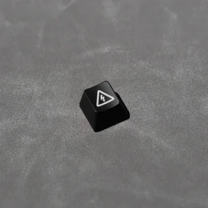Close-up of a black Electric Hazard danger keycap, featuring a striking backlit red and yellow industrial warning symbol. Edgy, high-contrast design.