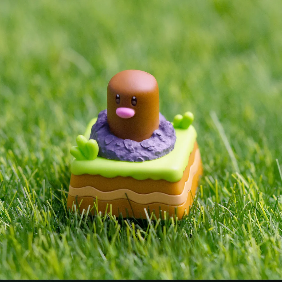 Close-up shots of the handcrafted resin Diglett & Psyduck Keycaps from various angles, revealing its whimsical Pokemon character and unique rotating artisan design.