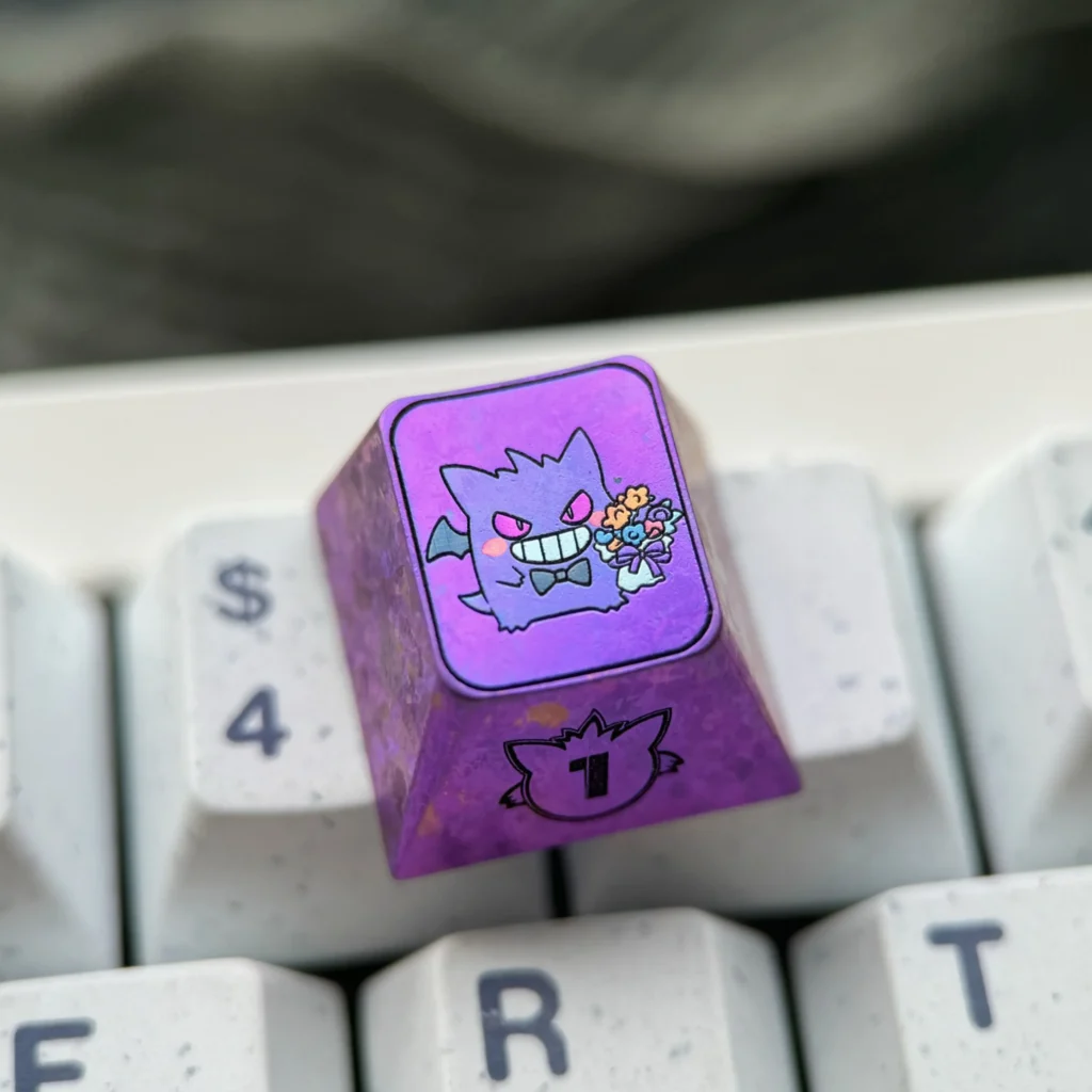 Premium titanium alloy Gengar artisan keycap, featuring a stylized Pokemon character and a captivating metallic purple finish for custom mechanical keyboard.