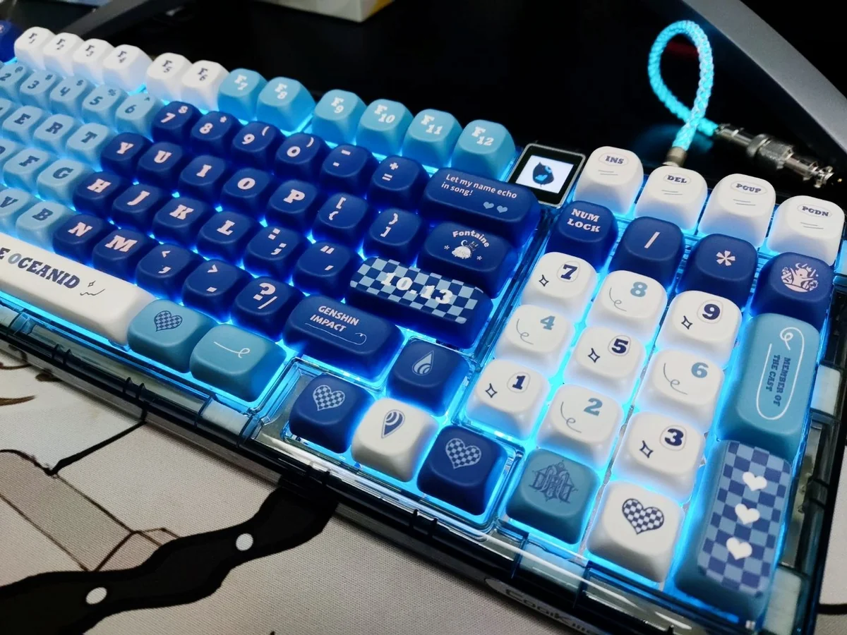 Close-up of elegant Furina PBT dye-sub keycaps set, showcasing vibrant blue, white, and gold Genshin Impact Fontaine motifs from multiple angles.