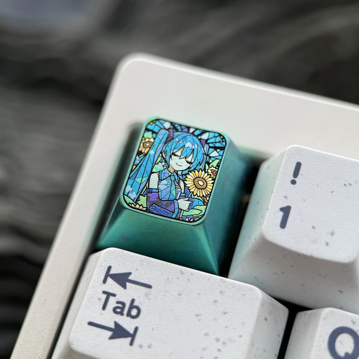 Close-up of the premium titanium Hatsune Miku keycap, showcasing its vibrant anime design with a sunflower motif and rich green accents from a unique keycap.