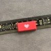 A premium Double-Shot ABS Backlit Heart Keycap, viewed from a slight angle, showcasing its glowing red translucent heart on a sleek red design.