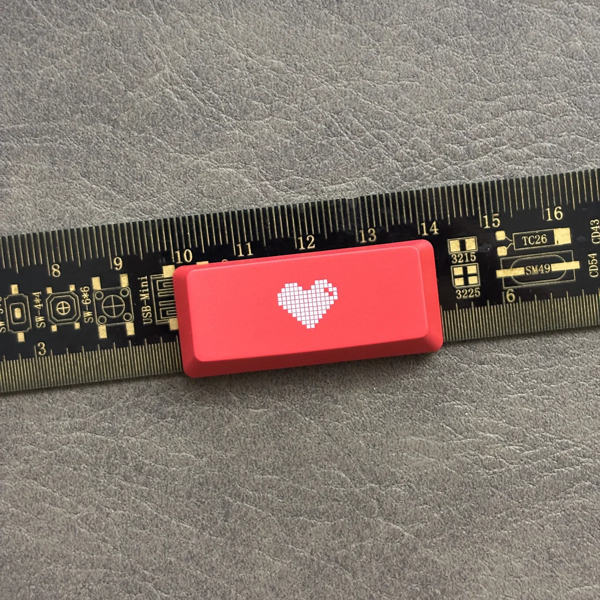 Premium double-shot ABS backlit heart keycap from various angles. Reveals its sleek black/red finish, translucent glowing heart icon.