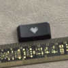 Premium black translucent double-shot ABS backspace keycap featuring a central glowing heart, designed for backlit mechanical keyboards.