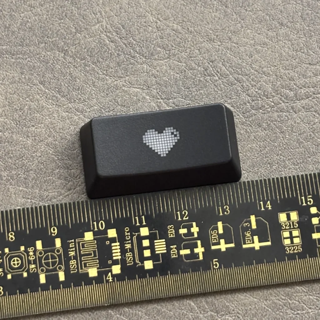 Premium black translucent double-shot ABS backspace keycap featuring a central glowing heart, designed for backlit mechanical keyboards.