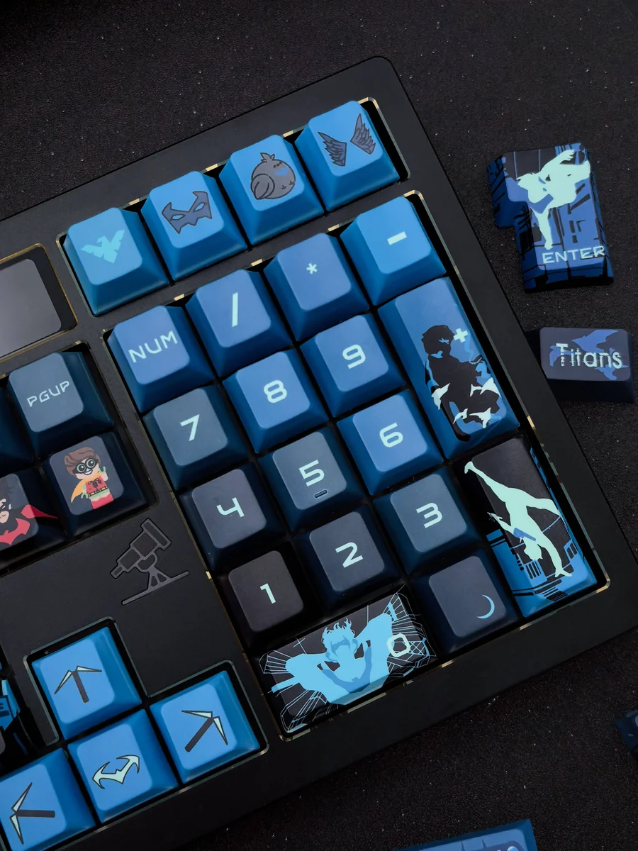Detailed views of the exclusive Nightwing Spirit artisan keycap set, highlighting its sleek dark blue and black design and iconic emblem.