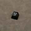 Edgy black ABS nuclear hazard keycap displayed from various angles, highlighting its unique backlit translucent radiation symbol and premium craftsmanship setup.