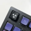 Sleek black ABS radiation keycap showcasing a vibrant, backlit nuclear hazard symbol for an edgy, distinctive custom keyboard.