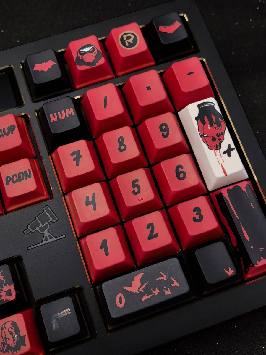 Premium Red Hood keycaps set, photographed from multiple angles, highlights the iconic DC vigilante spirit and bold red and black design.