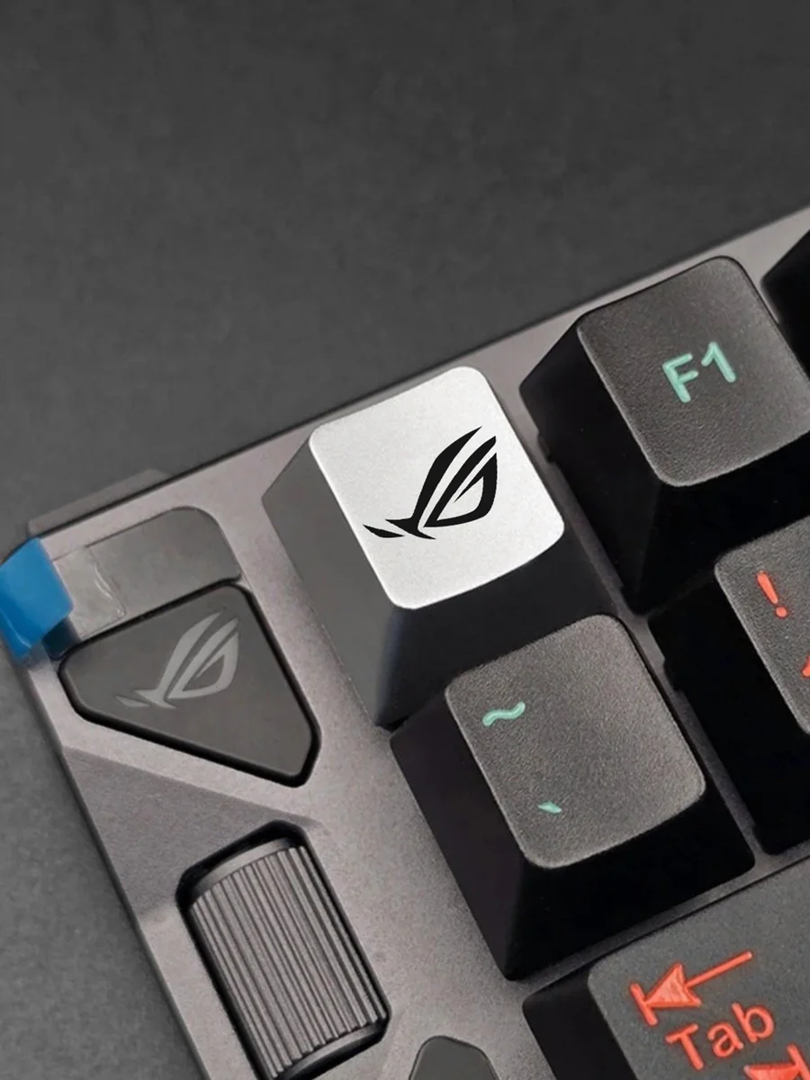 Iconic ROG Logo Alloy Keycaps. Aggressive angular design in premium metallic silver finish, showcased from multiple powerful angles.