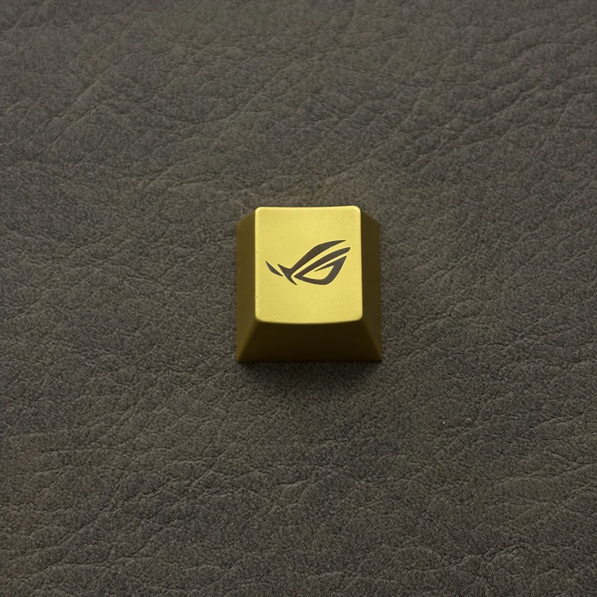 ROG Logo Alloy Keycaps from various angles, displaying its aggressive angular design and premium metallic finish.