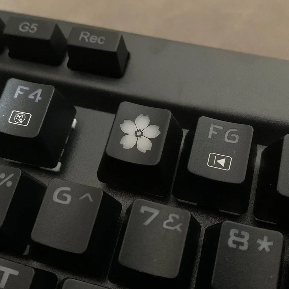 Close-up of the glowing Sakura ESC keycap, showcasing delicate cherry blossoms illuminated by RGB on premium backlit ABS, creating a tranquil artistic touch.