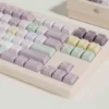A delightful gallery view of Taro Pistachio keycaps set, showcasing their sweet pastel purple, green, and cream dessert-inspired designs from various angles.
