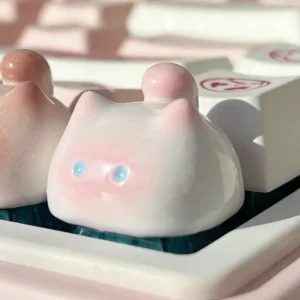 This whimsical handcrafted artisan keycap features an adorable pink blushing cat, a unique and expressive design for your keyboard.