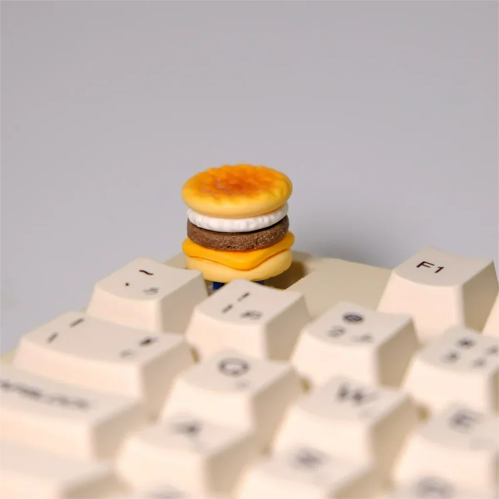 Handmade Mini Cod Fish Burger Keycap featuring a hyper-realistic miniature cheese cod burger with intricate textures and vibrant colors, showcasing unique craftsmanship.