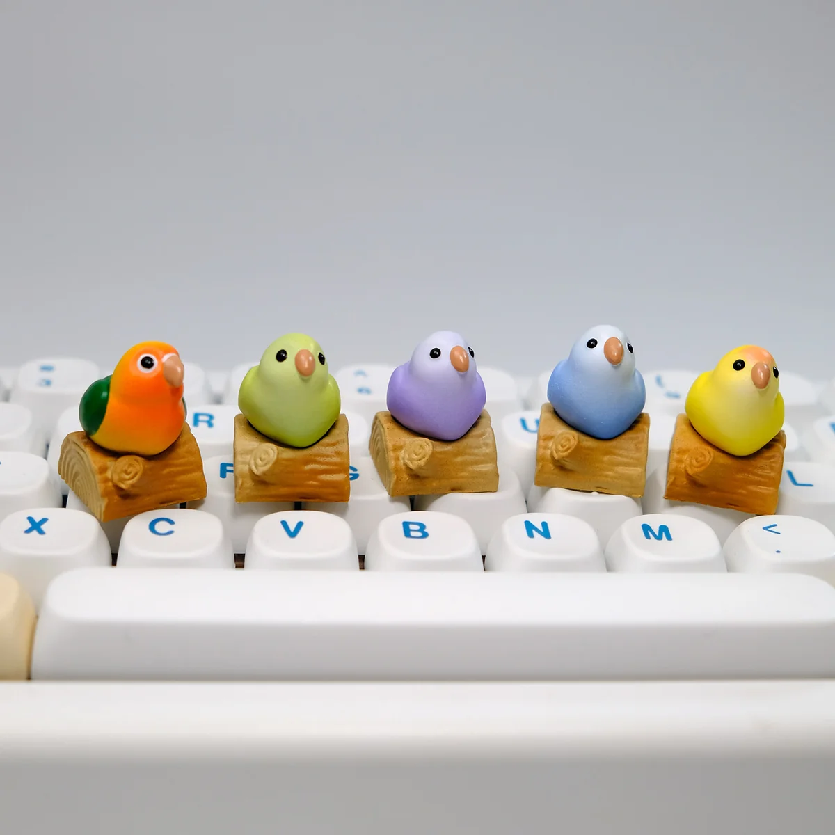 Vibrant hand-sculpted 3D artisan keycap, showcasing an intricate parrot from multiple angles, highlighting artistic detail.