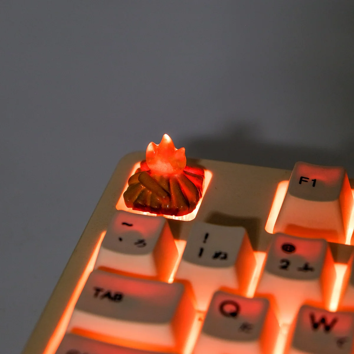 A close-up, dynamic angle of the handmade Glowing Bonfire 3D Artisan Keycap, revealing its intricate translucent resin sculpture and captivating warm setup/