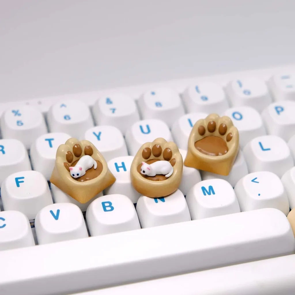 Whimsical handcrafted magnetic 3D Cat Paw Sofa Artisan Keycaps featuring a miniature white cat with blue eyes on a cozy custom sofa.