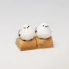 A charming handcrafted whimsical Bushtit artisan keycap, showcasing the adorable 3D sculpted forest bird playfully perched on its rustic log from an engagement.
