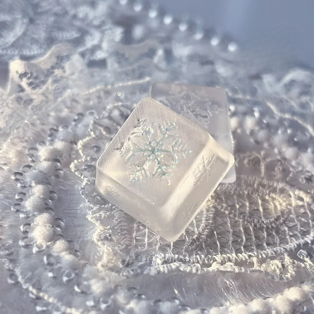 Handcrafted artisan snowflake keycap gallery views, revealing its translucent resin, ethereal glow, and delicate suspended snowflakes like winter's design.