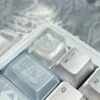 An ethereal translucent artisan snowflake keycap, handcrafted from resin, shown from various angles, glowing softly like winter's first snow.