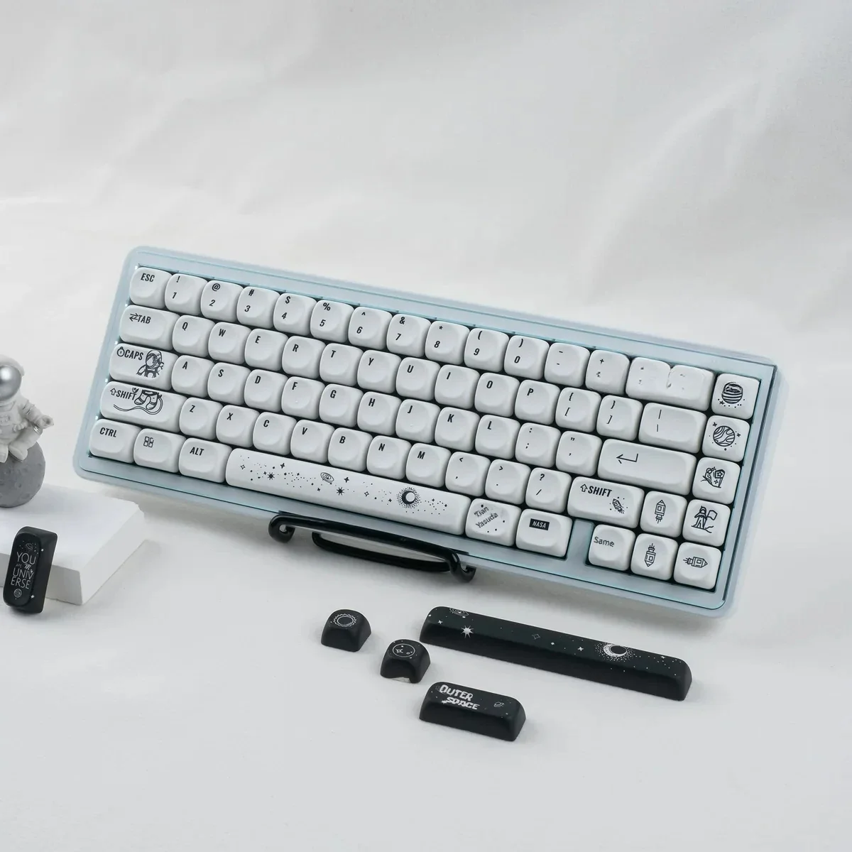 Close-up of PBT MOA astronaut keycaps set, revealing cosmic artistry with stylized astronauts and deep space hues. Durable, ergonomic design enhances celestial.