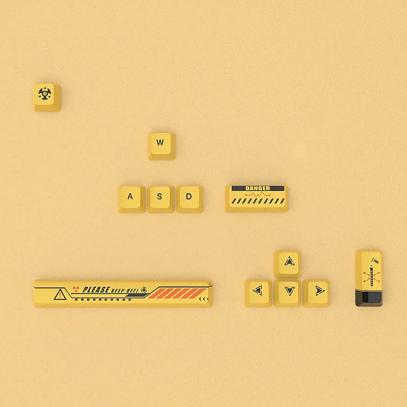 Close-up views of distinctive Biohazard PBT Dye-Sub Supplement keycaps set showcasing vibrant red and yellow toxic waste motifs on a dark, premium base.