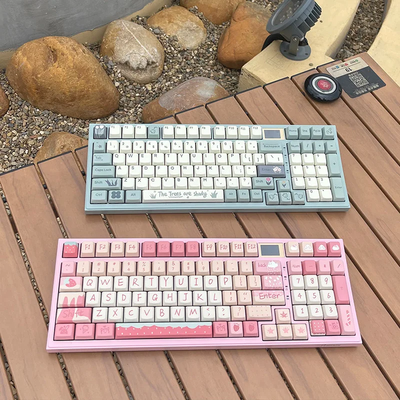 Artistic botanical keycaps set, featuring vibrant green illustrations and delicate floral accents on durable MDA PBT, presented from various angles to view.