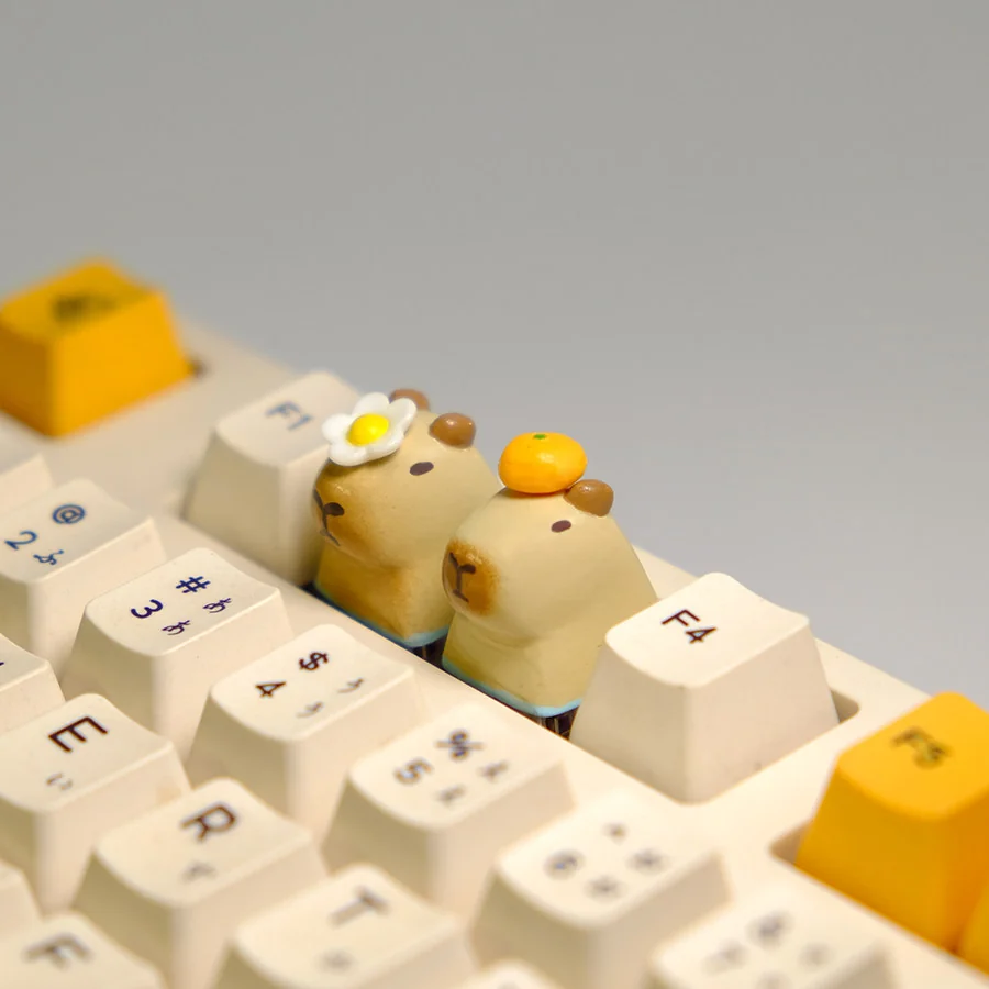 Adorable handmade resin Capybara With Orange & Flower keycap, showcasing its serene expression and a charming magnetic flora accessory from a front view.
