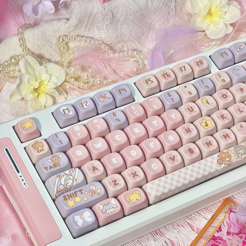 Iconic Cardcaptor Sakura PBT Dye-Sub Keycaps Set showcasing whimsical pastel pink and purple designs and magical anime motifs from different angles.