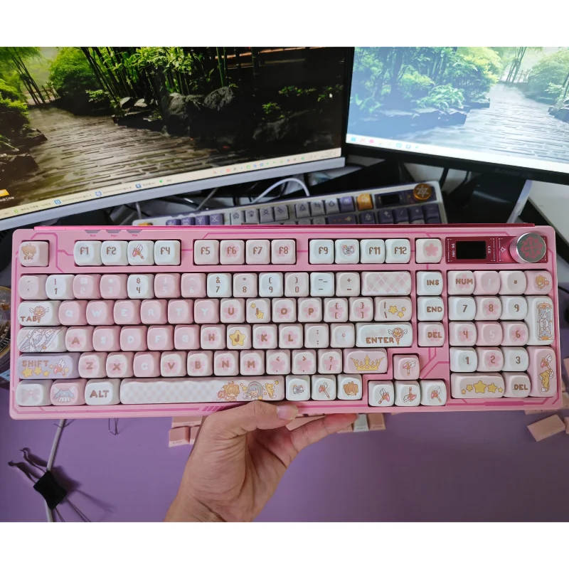 Whimsical Cardcaptor Sakura PBT dye-sub keycaps set in pastel pink and white MOA profile, presented in a magical box with a keycap puller.