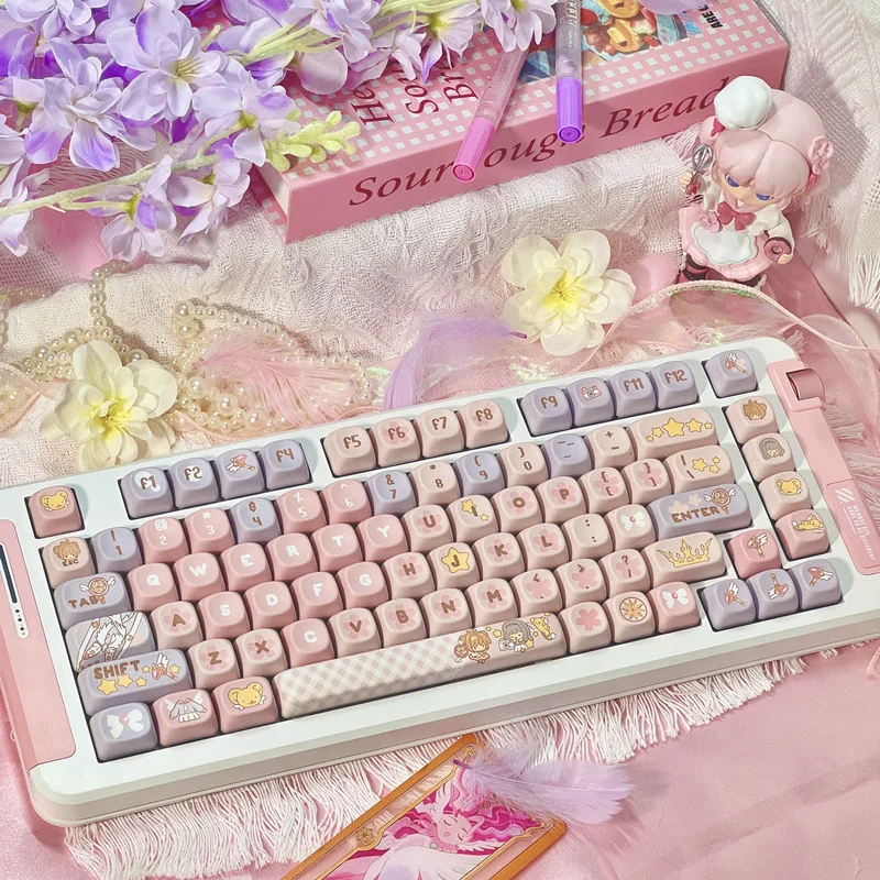 Whimsical Cardcaptor Sakura PBT dye-sub keycaps set in pastel pink and purple MOA profile, beautifully boxed with a keycap puller.