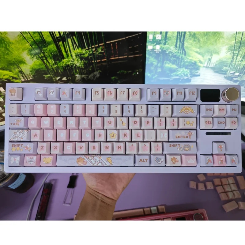 Whimsical Cardcaptor Sakura PBT dye-sub keycaps set in pastel pink and purple, beautifully boxed with a keycap puller for easy installation.