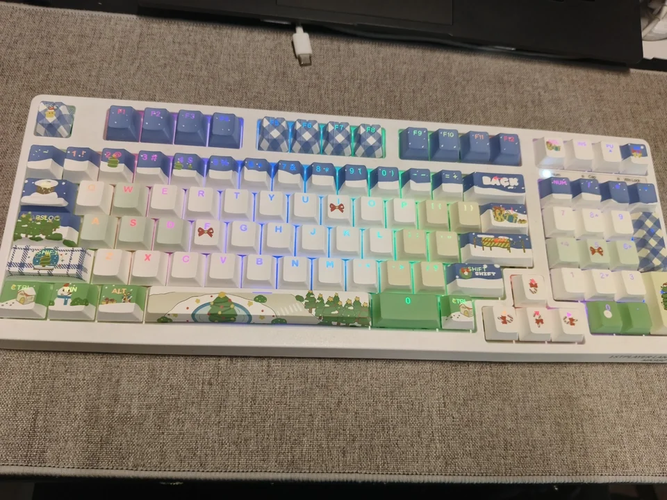 Festive blue PBT Christmas keycaps set, front-engraved and translucent, with charming winter wonderland icons, offering durable, artistic charm.