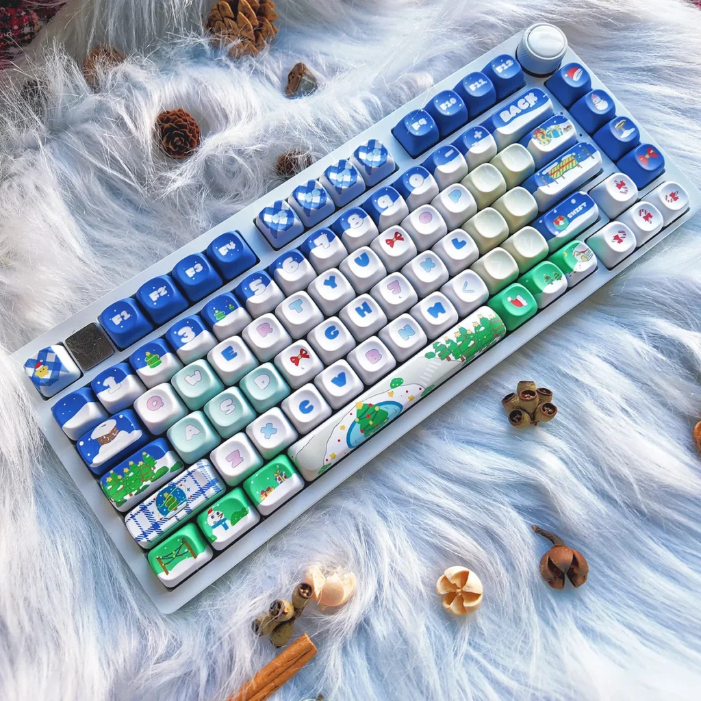 Artistic festive blue PBT Christmas keycaps set featuring cozy winter wonderland designs, perfect for a unique keyboard aesthetic.