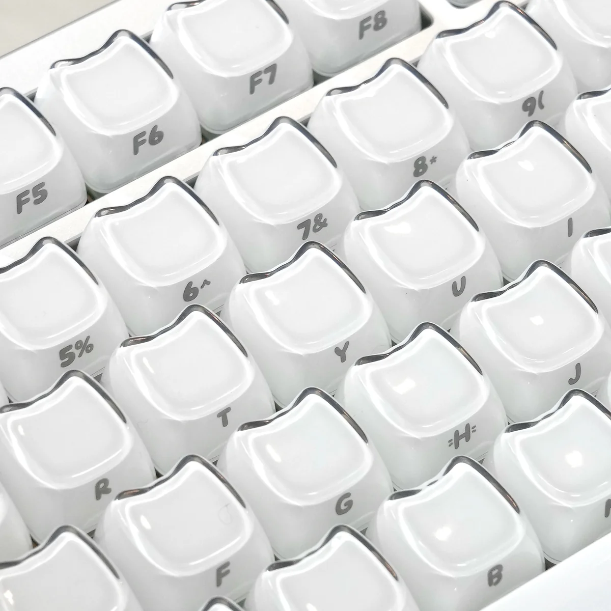 Close-up of translucent pastel Crystal Jelly MAO keycaps set featuring playful cat art and a sleek ergonomic profile, highlighting their double-layered depth.