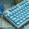 Artistic views of durable PBT dye-sub Summer Keycaps Set. Pastel blues, greens, whites evoke a serene, sun-drenched summer.